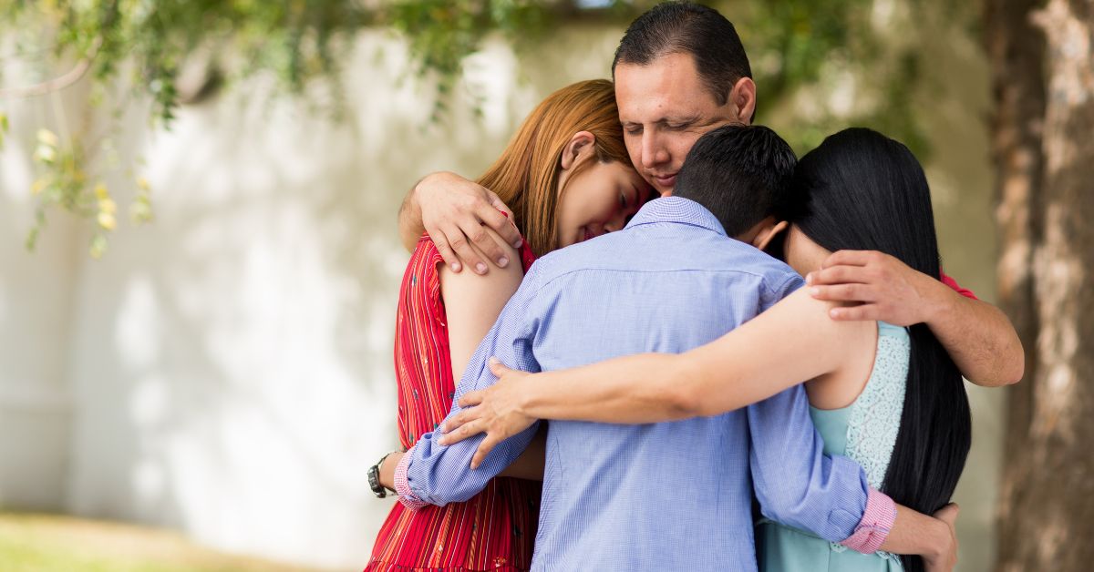 Culturally specific blog Feature A Latine family of four embrace each other in a family hug.